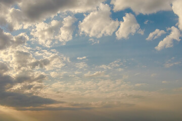 Sunlight streams through a moody sky filled with dark and light clouds, creating a dramatic and...