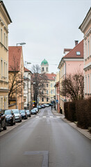 Fototapeta premium quiet residential street with pastel-colored buildings on an overcast day