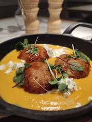 Cutlets in pumpkin sauce with feta cheese and herbs