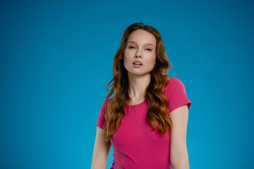 Woman poses with confidence and emotion in a studio against a bold blue background showcasing her...