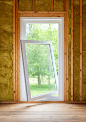 newly installed white window tilted open in a home under construction