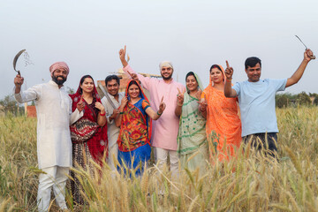 Goup of rural indian farmers standing together at agriculture field ready to harvest wheat crop....