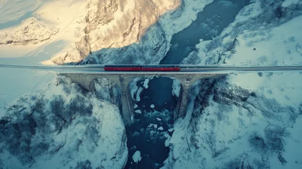 Aerial view of landwasser viaduct with a red train crossing over snowy mountains, Bergun Filisur, Switzerland.