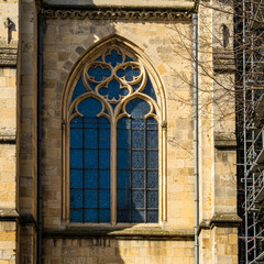 Obraz premium detailed view of a gothic-style stained glass window set in an aged stone building