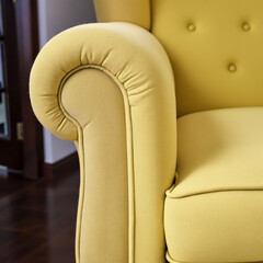 Obraz premium close-up of a pale yellow armchair with detailed stitching