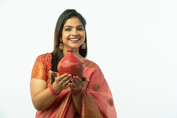 Smiling Attractive Beautiful Indian Woman showing piggy bank wearing traditional colorful saree in...