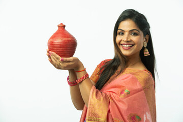 Smiling Attractive Beautiful Indian Woman showing piggy bank wearing traditional colorful saree in...