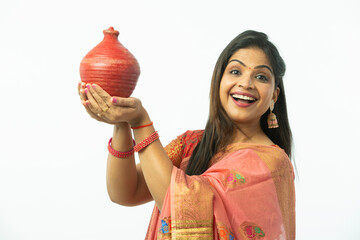 Smiling Attractive Beautiful Indian Woman showing piggy bank wearing traditional colorful saree in...