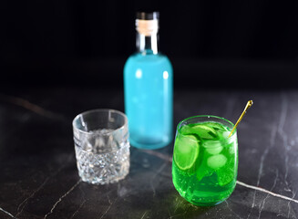 Mojito cocktail with lime wedges and ice on black background