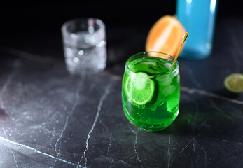 Mojito cocktail with lime wedges and ice on black background