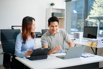 Female discussing new project with male colleague. Young woman talking in office