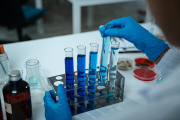 In the laboratory, a group of professional researchers gather around a chemical tube, checking samples for medical analysis and conducting chemistry experiments to ensure accurate results.
