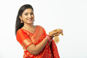 Indian woman holding gold jewelry, ornaments - Asset or Gold Loan concept, Beautiful, smiling and attractive indian women face isolated in white background theme.