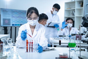In the laboratory, blood is carefully dripped into test tubes for medical and biology research,...