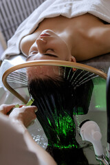 Close-up of a woman receiving a relaxing Japanese head spa treatment, with green massage sticks...