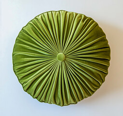 Green cushion with an adorable, pleated design is presented