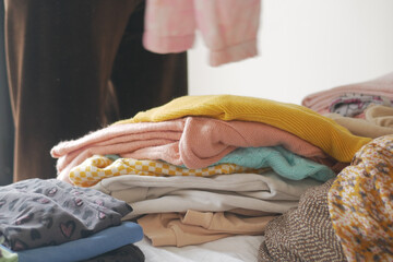 Folding colorful clothes on a bed during a weekend chore