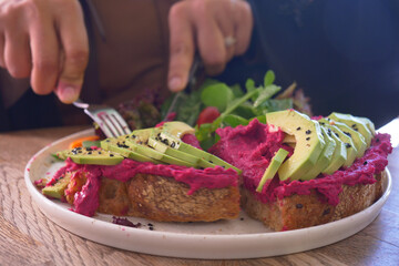 Healthy brunch with avocado toast and colorful salad on wooden table