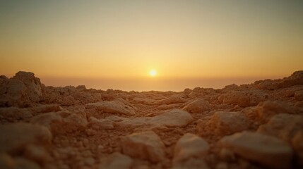 Obraz premium Uneven stones create a winding path leading toward the horizon, illuminated by warm golden light, evoking feelings of adventure and exploration