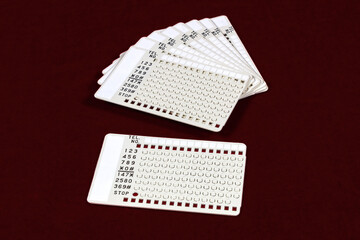 Vintage autodial punchcards for 1970s touchtone telephone. Numbers were programmed by punching out the appropriate number on the card. 
