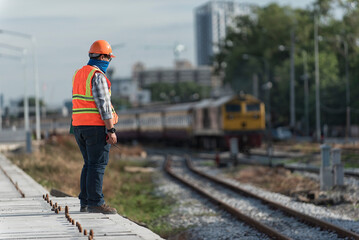 Obraz premium Engineer Inspecting Railway Track During Construction