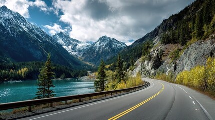 Fototapeta premium Winding Highway Surrounded by Towering Mountain Peaks and Lake