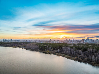 Fototapeta premium Colorful autumn forest with trees on the shore of a blue lake - top aerial view.