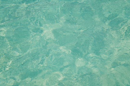 abstract blue turquoise background of crystal clear transparant ocean or swimming pool water with ripples 