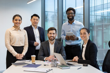 A diverse team of business professionals smiling and looking at the camera, ready for success and collaboration.