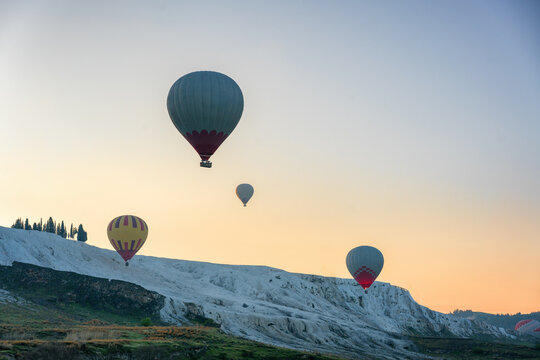 Hot air balloons flying over Pamukkale travertines at sunrise