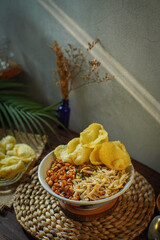 Indonesian chicken porridge (bubur ayam) served with shredded chicken, crackers, soy sauce, and...