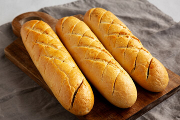 Homemade French Baguette with Garlic Filling on a wooden board, side view.