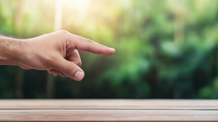 Fingertips pinching closeup hand gesture with blurred green background and wooden surface in natural light