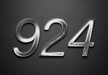 Chrome metal 3D number design of 924 on grey background.