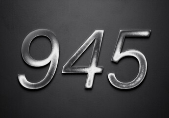 Chrome metal 3D number design of 945 on grey background.