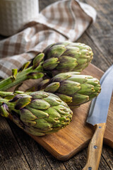 Ripe artichokes plant on cutting board.