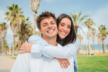 Fototapeta premium A cheerful couple sharing a loving embrace, radiating happiness and affection in a delightful outdoor setting, creating a memorable moment together filled with joy and warmth.
