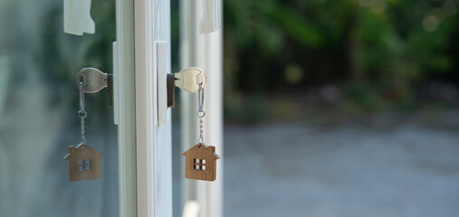 Landlord key for unlocking house is plugged into the door. Second hand house for rent and sale. keychain is blowing in the wind. mortgage for new home, buy, sell, renovate, investment, owner, estate