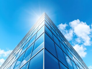 Modern Glass Building Reaching Toward Blue Sky with Sunlight Reflection