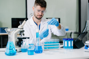 Fototapeta premium male scientist working with micro pipettes analyzing biochemical samples, advanced science