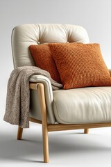 A white leather bed with wooden legs, a beige-brown blanket on top of it, and an orange pillow on the left side. 