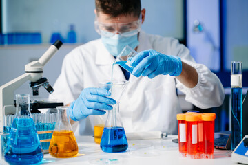 Scientist mixing chemical liquids in the chemistry lab. Researcher working in the laboratory