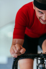 A triathlete riding a triathlon bike on a machine simulation in a modern living room. Training...