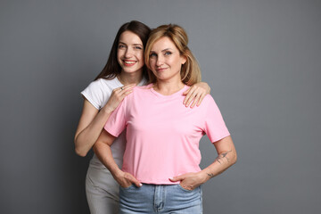 Fototapeta premium Portrait of mother and daughter on grey background
