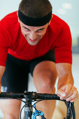 A triathlete riding a triathlon bike on a machine simulation in a modern living room. Training...