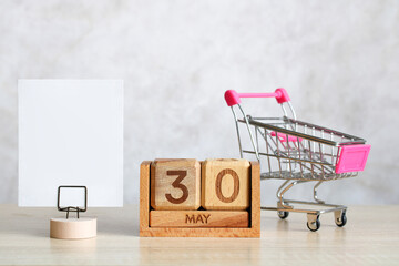 May 30th wooden calendar with shopping cart and blank sign for text