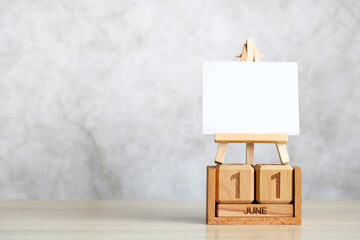 Wooden perpetual calendar showing june 11 with blank canvas on easel