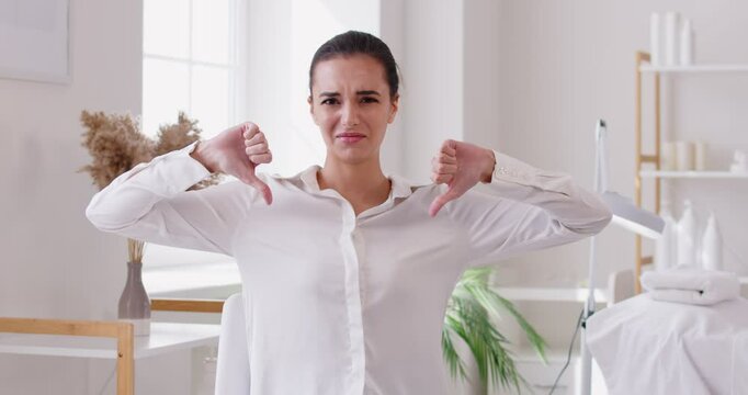  Woman skin care expert shows thumbs down disapproves beauty standards gives negative feedback on harmful habit debunks myth busts viral Internet hack gives example of product she will never buy
