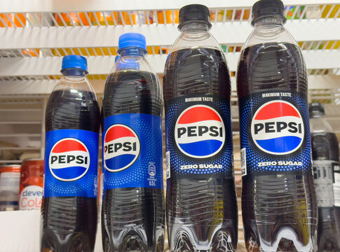 Assorted pepsi bottles on store shelf: regular and zero sugar variants