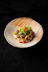 A beautifully arranged plate of Asian-inspired dish featuring tender beef mixed with bell peppers...